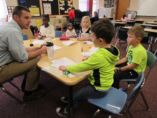 Students and teacher sitting around a table