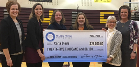 Image of Carla Diede holding large $25,000 check with several previous South Dakota Milken Educator Award winners.
